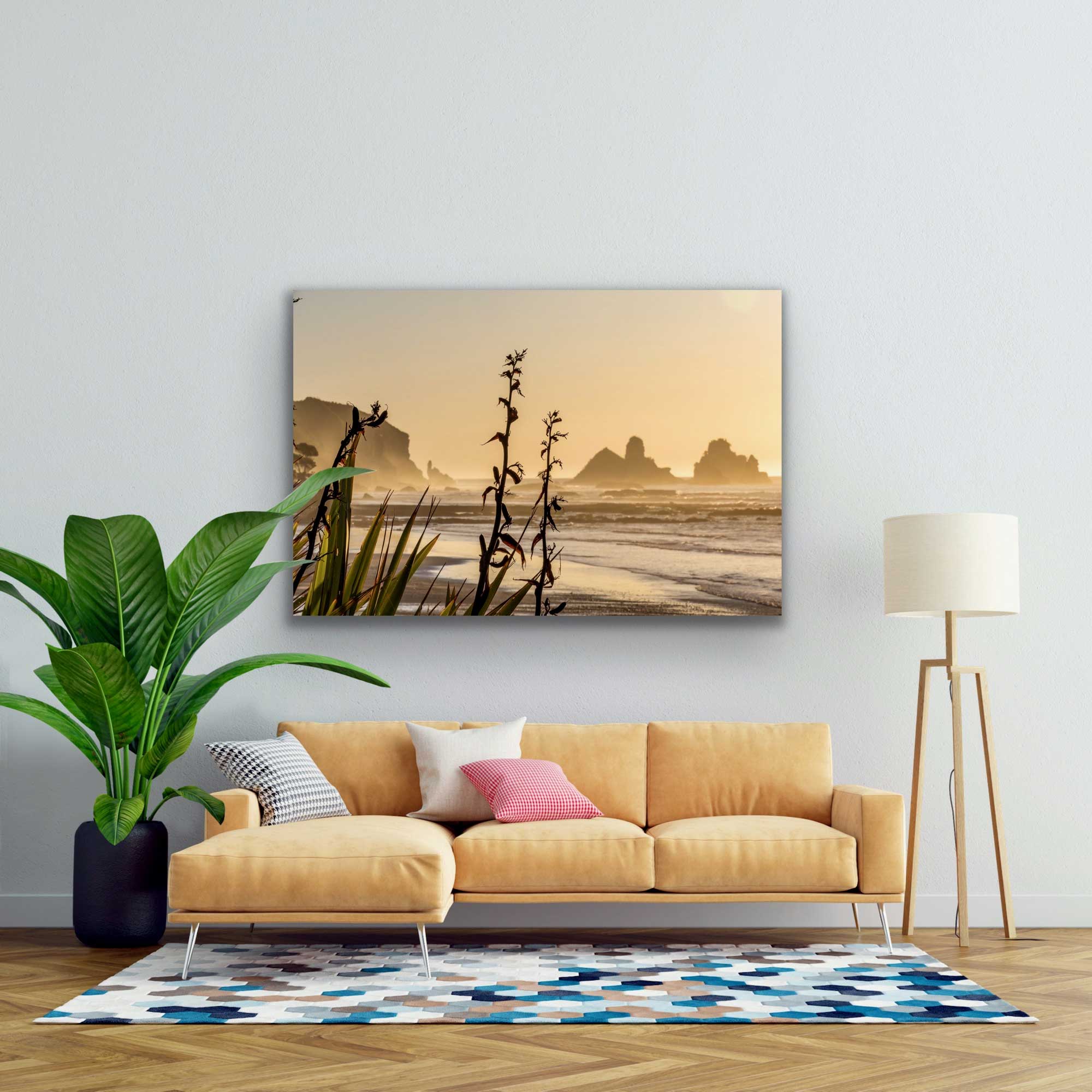 Subtly coloured Motukiekie Beach photograph in situ, hung above a couch and potted plant. Beautiful NZ beach photography for sale.