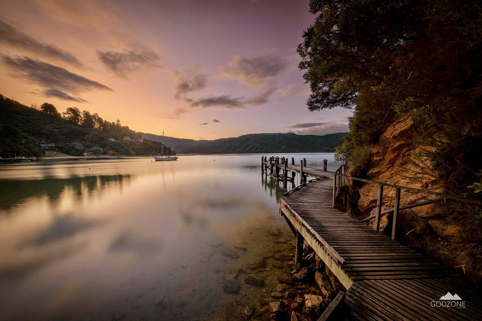 Sunset landscape photograph of the boardwalk around Bythell's Bay in Waitaha, Queen Charlotte Sound