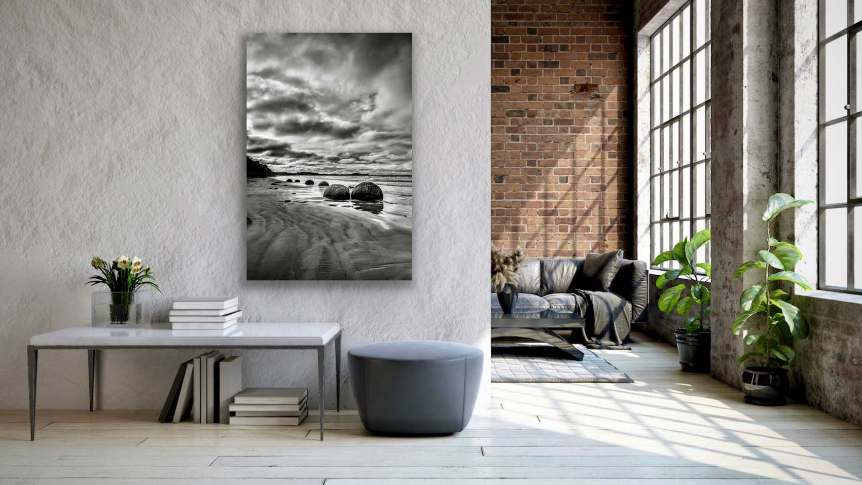 Tall black and white Moeraki Boulders photograph in situ, hung on the wall above a small side table. See tall greyscale landscape photography on the wall.