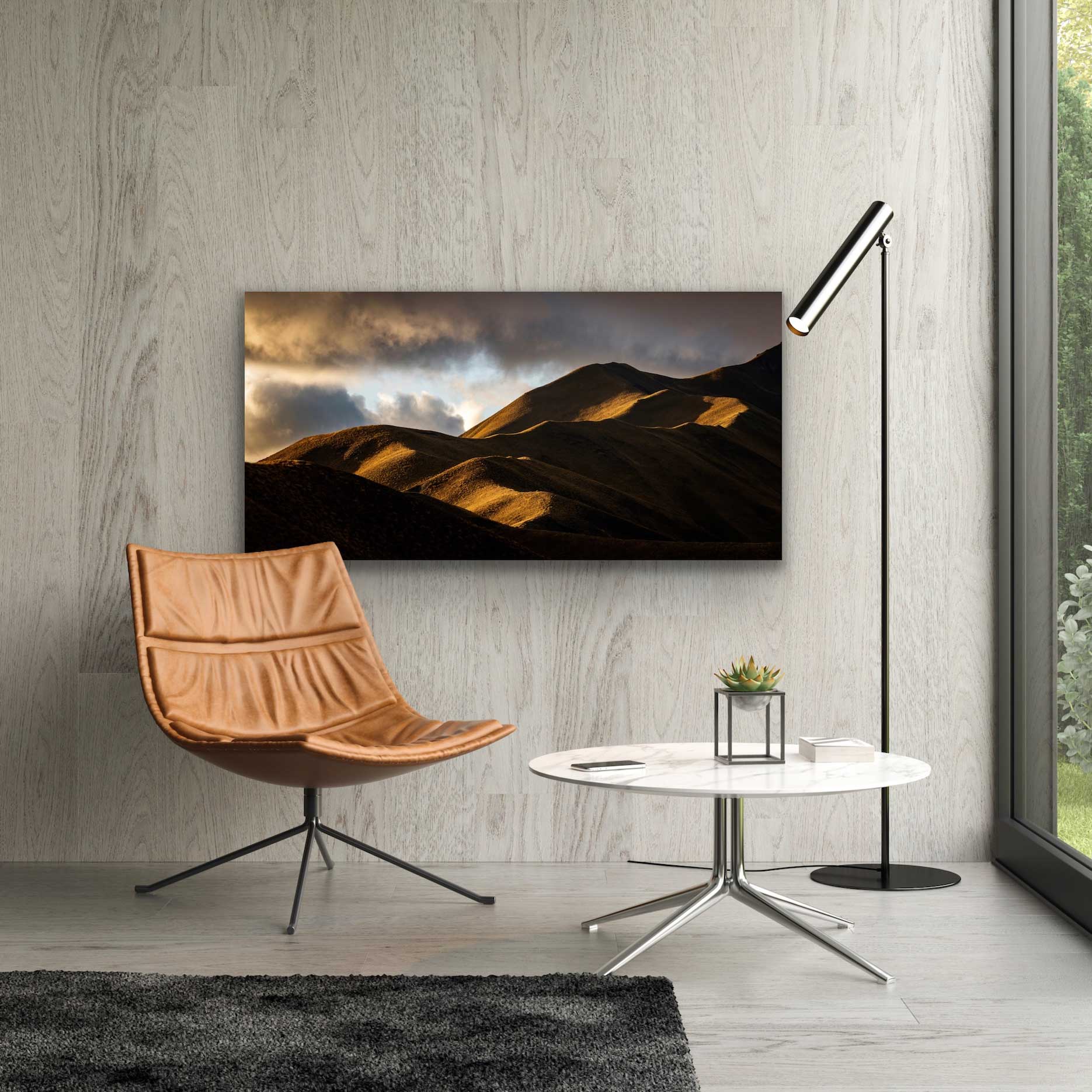 Rolling golden hills in Lindis Pass photograph in situ on the wall above a coffee table and chair. Beautiful NZ landscape photography for sale.